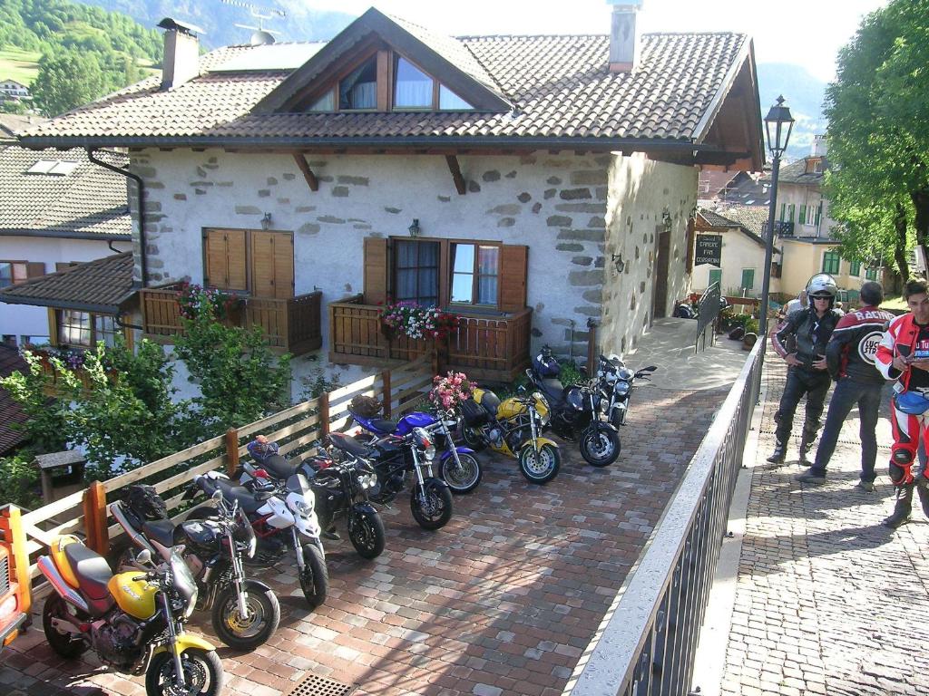 een groep motorfietsen geparkeerd voor een huis bij B.& B. Corradini in Castello di Fiemme