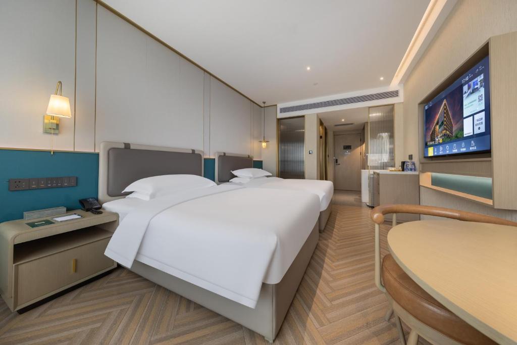 Postel nebo postele na pokoji v ubytování Guangzhou Baiyun Airport MeHood Liz Hotel Free Shuttle Bus To Airport