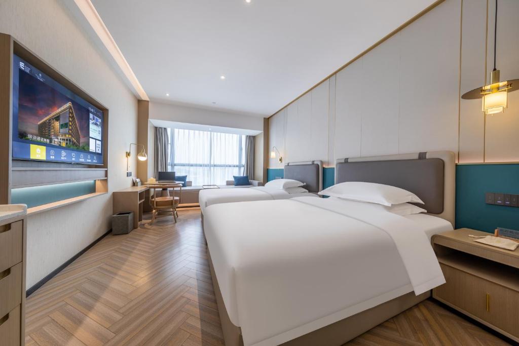 Postel nebo postele na pokoji v ubytování Guangzhou Baiyun Airport MeHood Liz Hotel Free Shuttle Bus To Airport