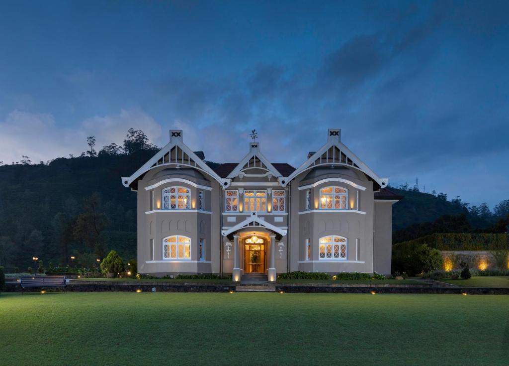 a large house with a large lawn at night at The Bellwood Manor in Nuwara Eliya