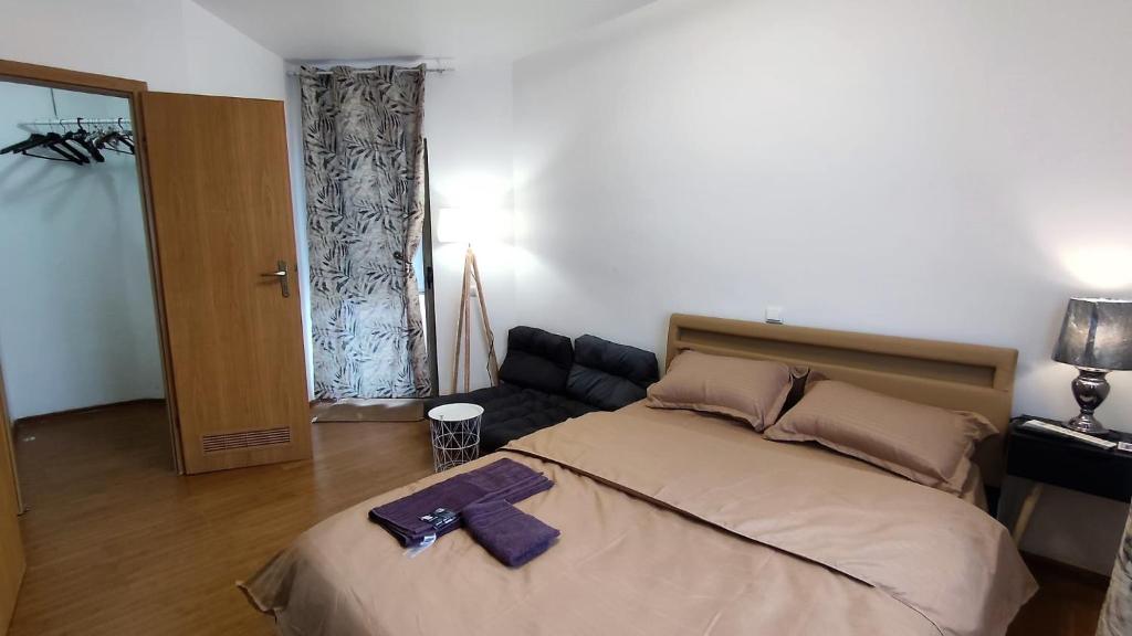 a bedroom with a bed with a purple robe on it at Lake view luxury apartment in Bucharest