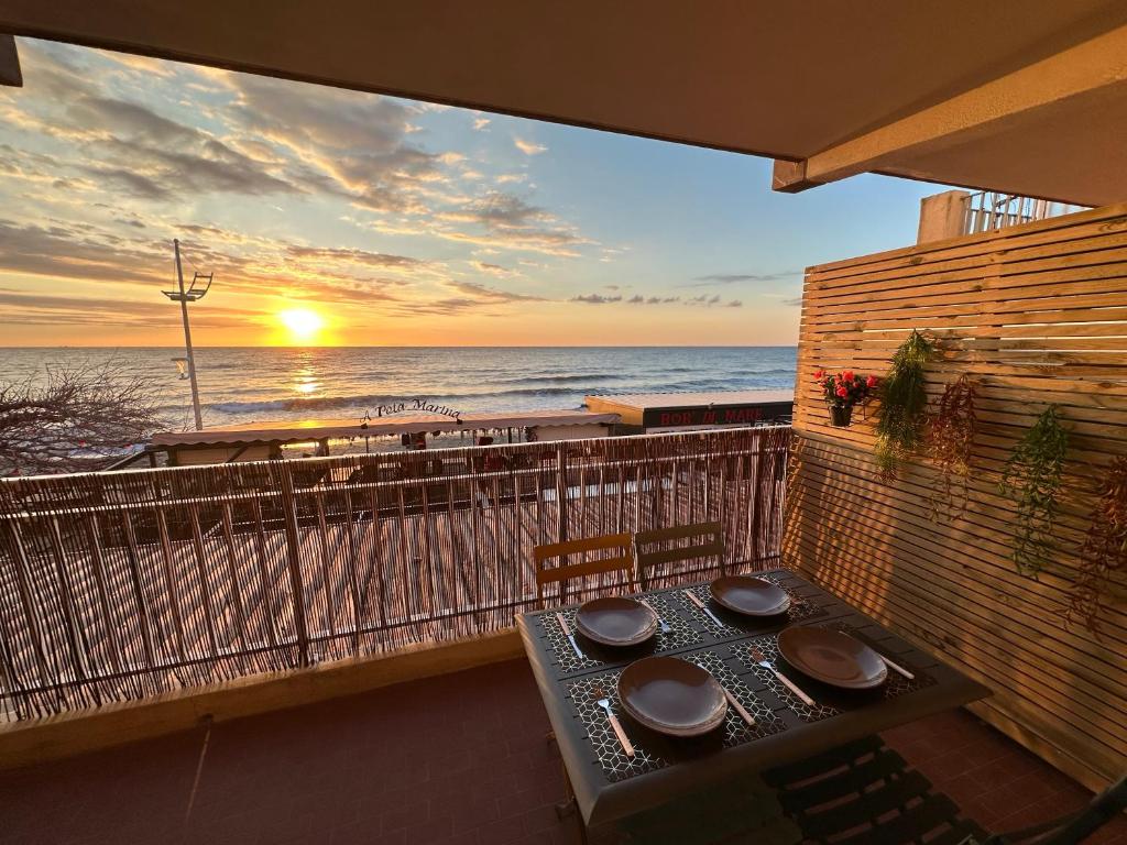 een tafel op een balkon met uitzicht op de oceaan bij Studio bord de mer in San-Nicolao