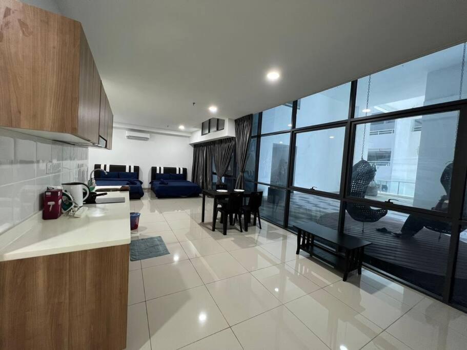 a kitchen and living room with a large window at Pacific Tower PJ Section 13 WifiParkingOppJayaOne Mall in Petaling Jaya