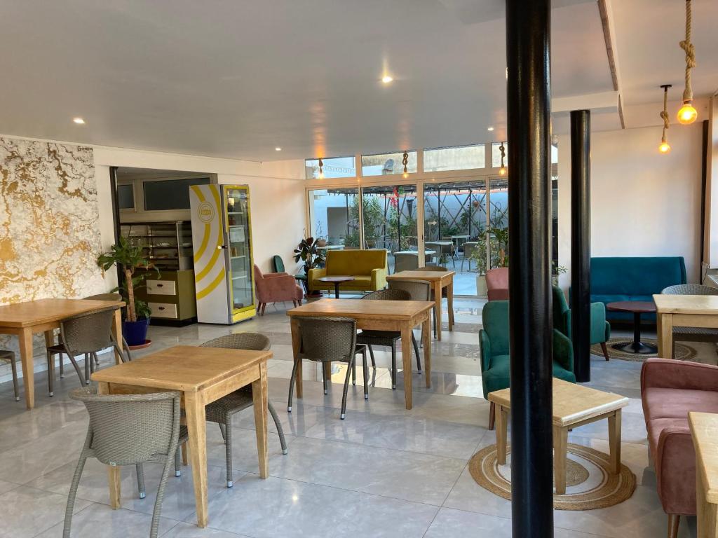 a restaurant with tables and chairs and windows at Ezz'Hotel Canet in Canet-en-Roussillon