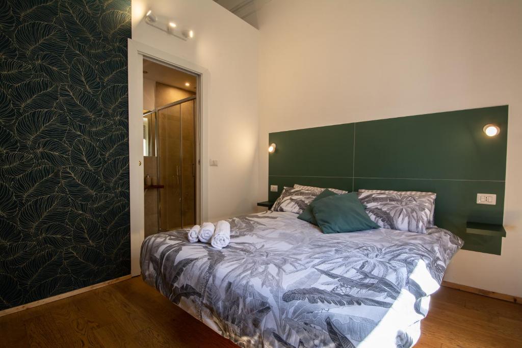 a bedroom with a large bed with a green headboard at VelaCatania rooms in Catania