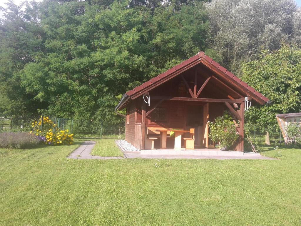 a small wooden pavilion in a field of grass at Tiny Home am Bach in Pettenbach