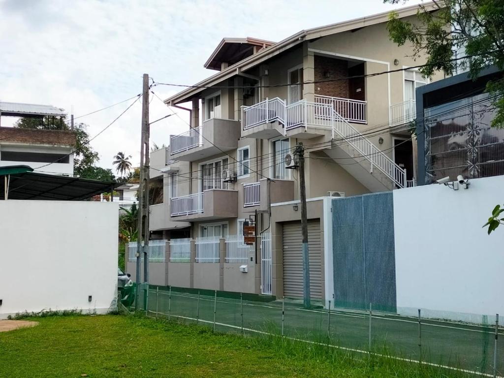 an apartment building with balconies and a fence at Square One CONDO - Kelaniya in Kiribathgoda