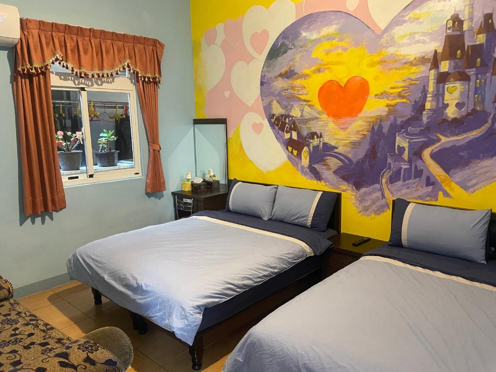 a bedroom with two beds and a painting on the wall at Green Island Xinmanyuan綠島馨滿園 in Green Island