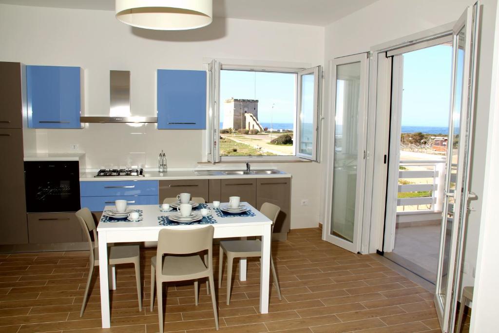 een keuken en eetkamer met een tafel en stoelen bij Altomare Case Vacanza in Torre Lapillo