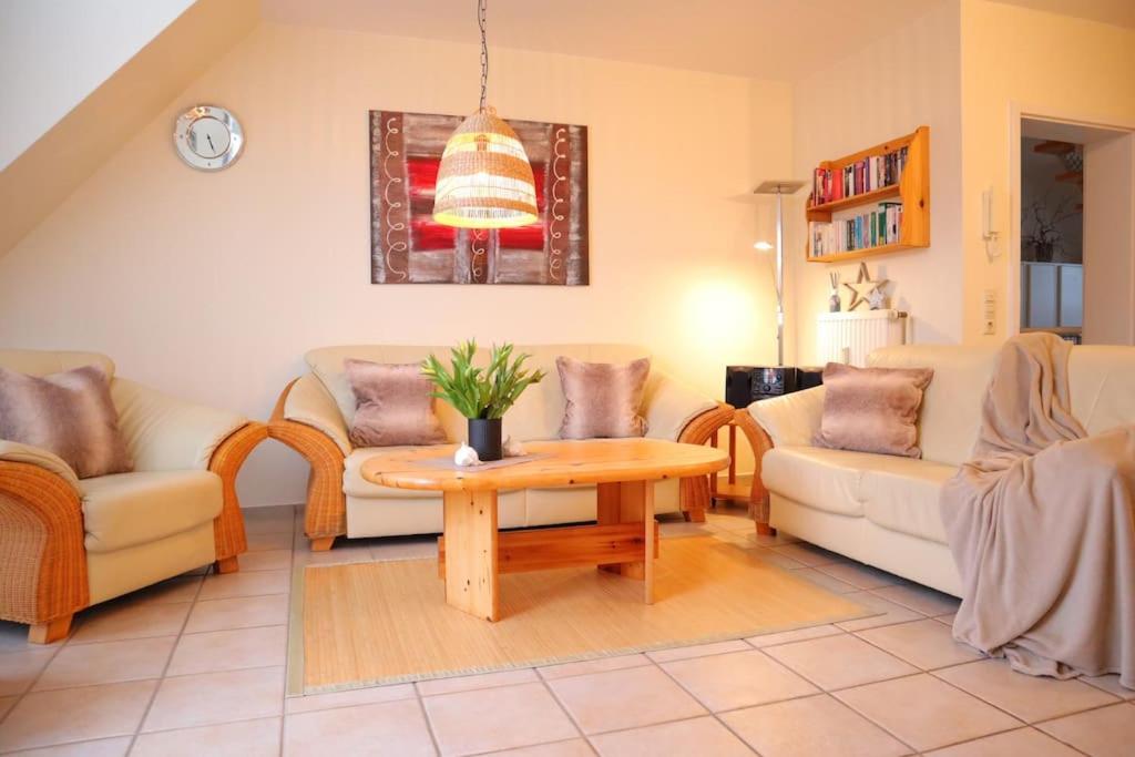 a living room with two couches and a table at Ferienwohnung Strandaster in Spieka-Neufeld
