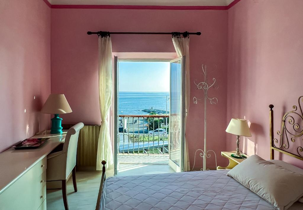 sypialnia z łóżkiem i widokiem na ocean w obiekcie Splendido appartamento con vista mare su piazza Dante w mieście Varazze