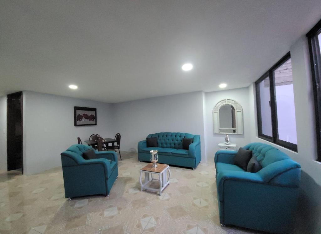 una sala de estar con 2 sofás azules y una mesa. en Depa Zona centro, en Irapuato