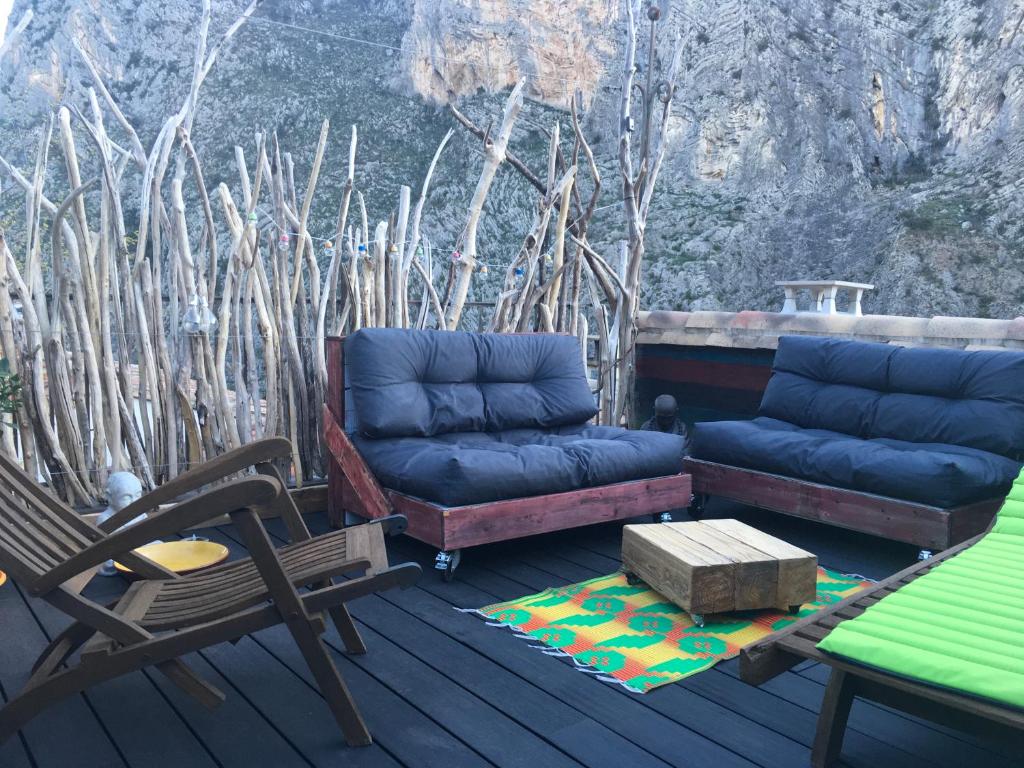 a deck with a couch and a table and chairs at Le monde de Théodore in Anduze