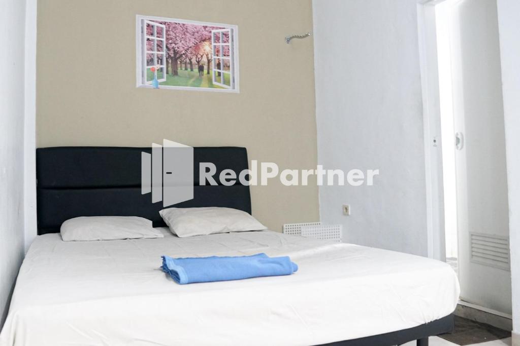 un letto con un cuscino blu seduto sopra di Cosmo Harmoni RedPartner a Giacarta