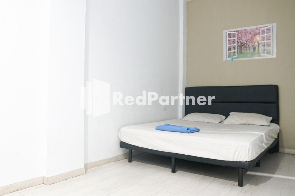 a bed in a room with a white mattress at Cosmo Harmoni RedPartner in Jakarta