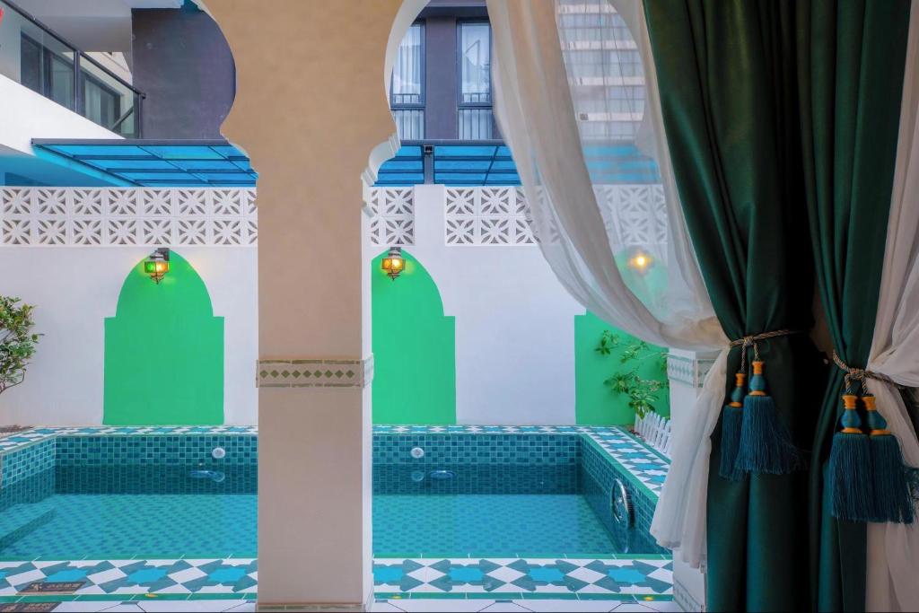 una piscina en una casa con azulejos azules y verdes en Morocco Green House Forest, en Huidong