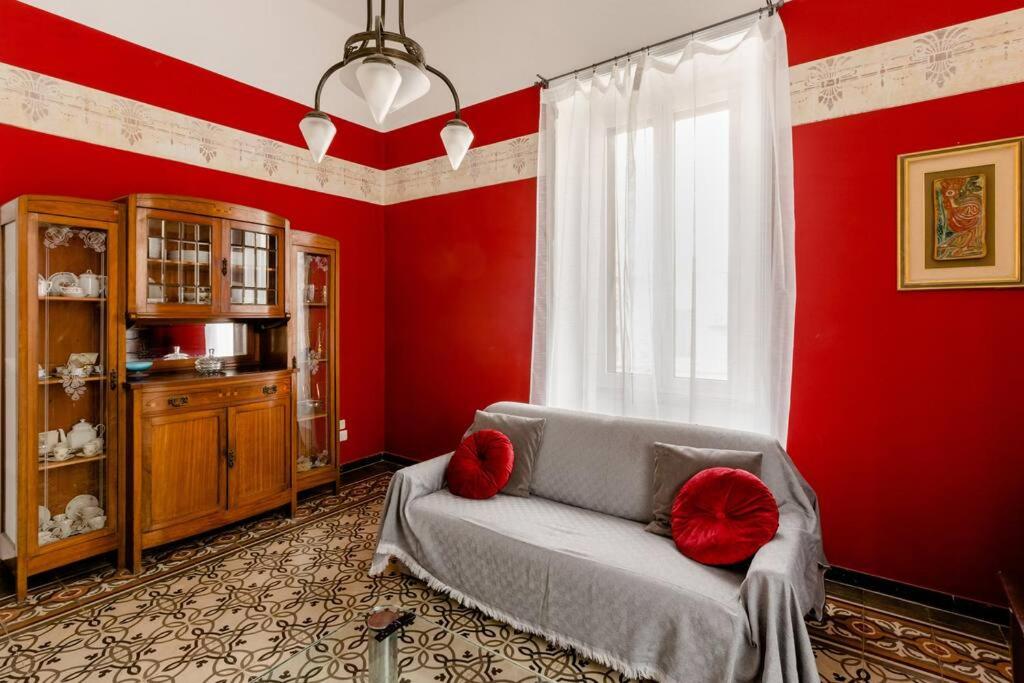 een woonkamer met rode muren en een bank met rode kussens bij Casa Jole, appartamento in centro in Bari