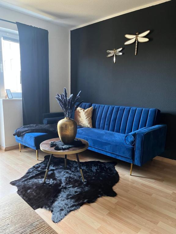 馬格德堡的住宿－Apartment mit guten Anbindungen，客厅配有一张蓝色的沙发,配有一张桌子