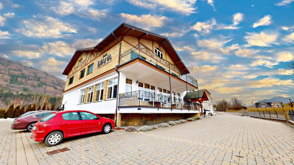 Un coche rojo aparcado delante de un edificio en Hotel Diana, en Žilina