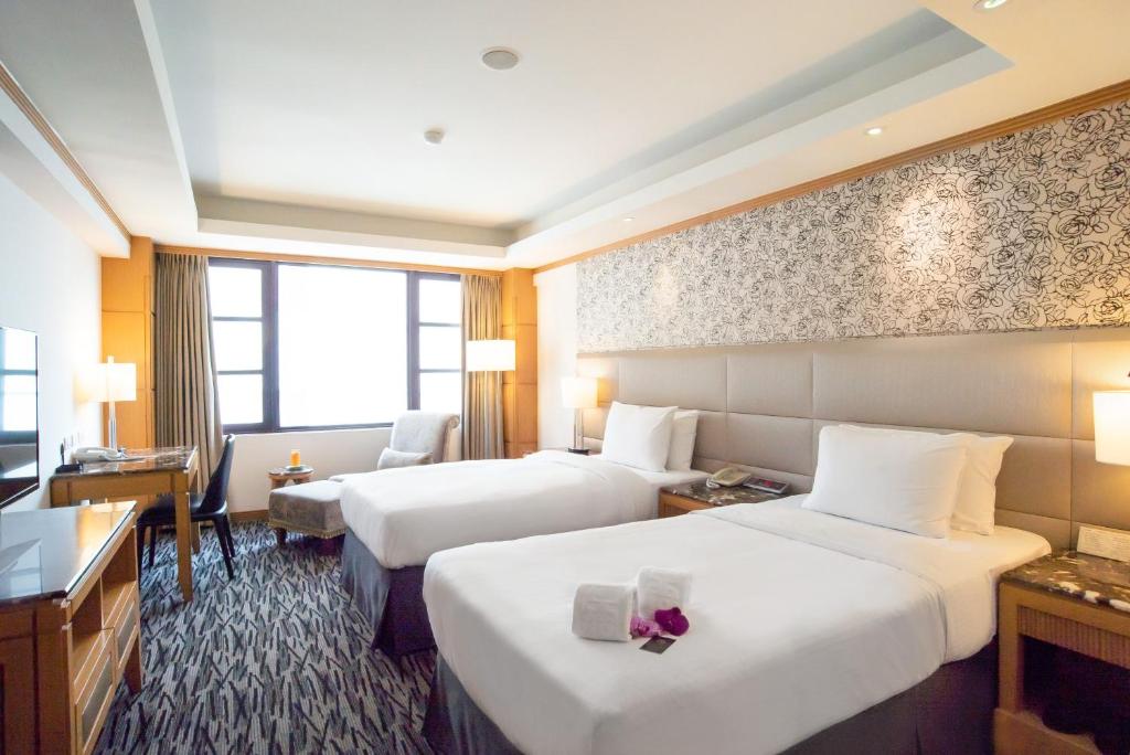 台中市にあるホテル ディオンのベッド2台とデスクが備わるホテルルームです。