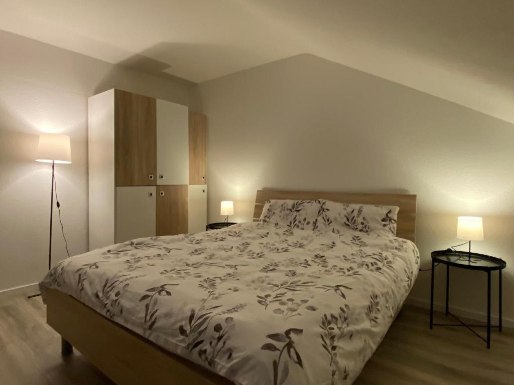 1 dormitorio con 1 cama grande y 2 lámparas en Marienhaus Apartment - Zentral, Parken, Netflix, Kontaktloses Einchecken, en Wuppertal