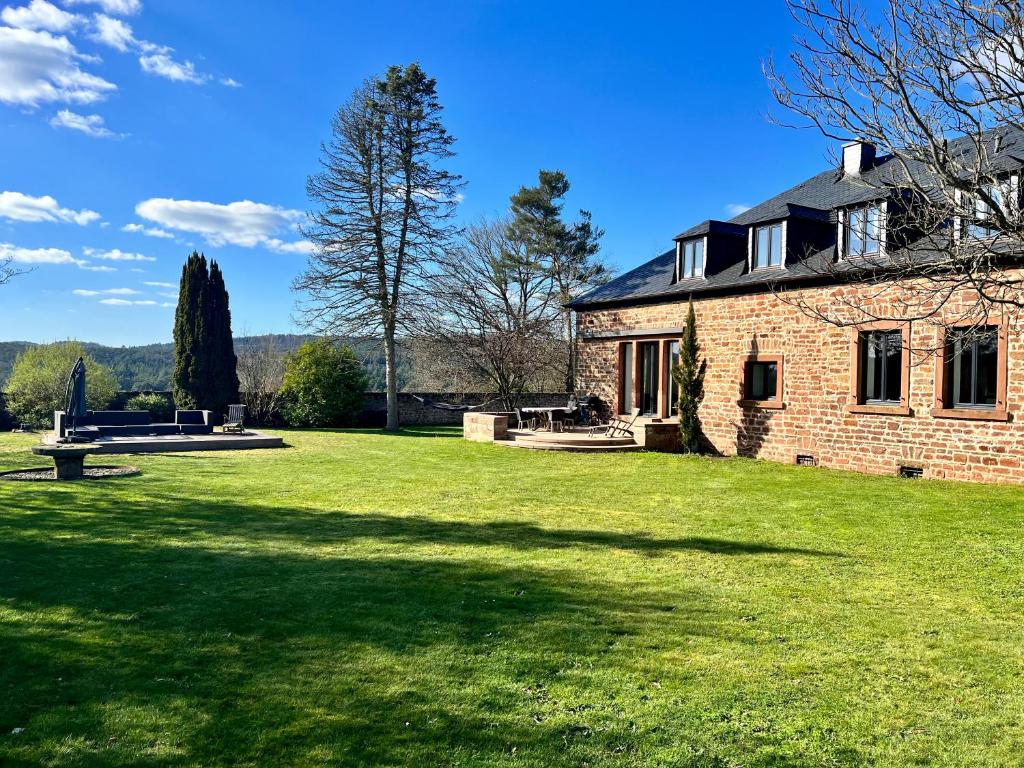 een stenen huis met een grote grastuin bij Trierer Heide - Architektur zum wohl fühlen in Trier