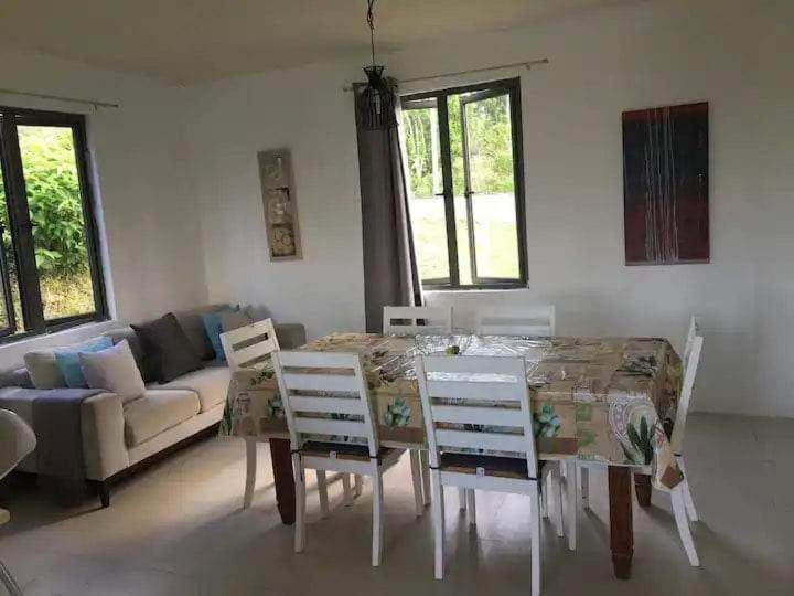 sala de estar con mesa, sillas y sofá en Le Kato Lux Rodrigues, en Rodrigues Island