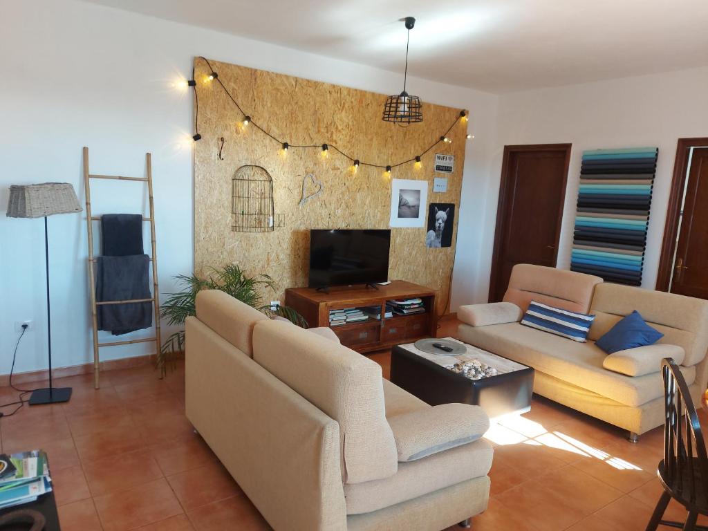 Sala de estar con 2 sofás y TV en Casa Elsa, en Puerto del Rosario