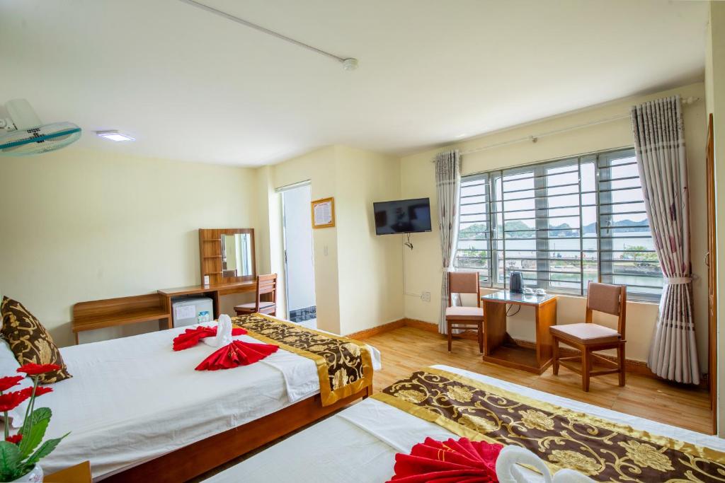 a hotel room with a bed and a table and chairs at Ngọc Linh 2 SeaView Hotel in Cat Ba