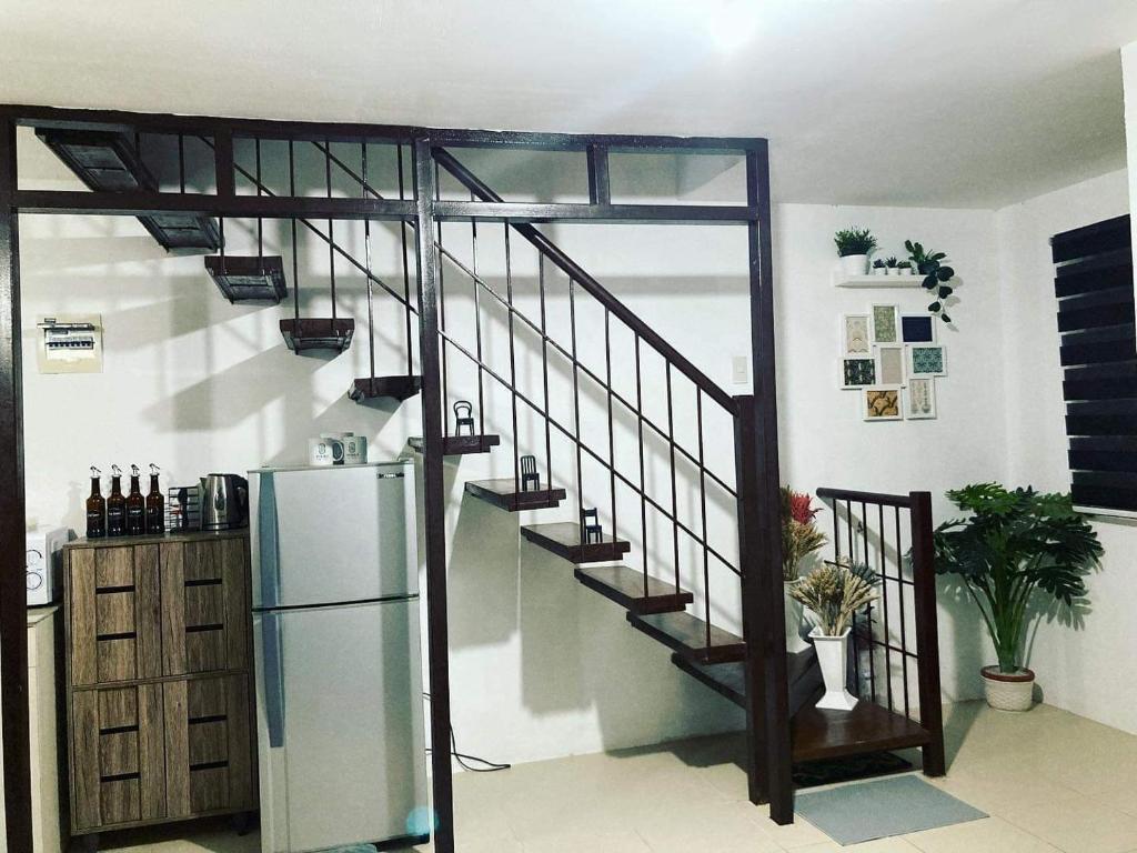 a kitchen with a staircase and a refrigerator in a room at salty dog homestay in Batangas City