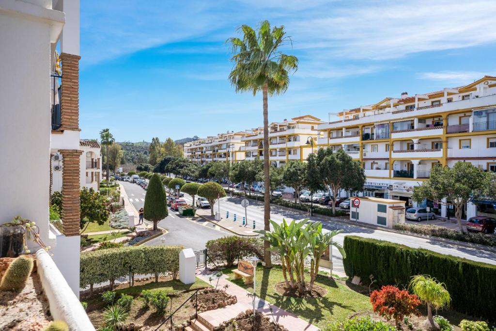a view from the balcony of a building with a palm tree at Golf course view apartment Ref 198 in Fuengirola