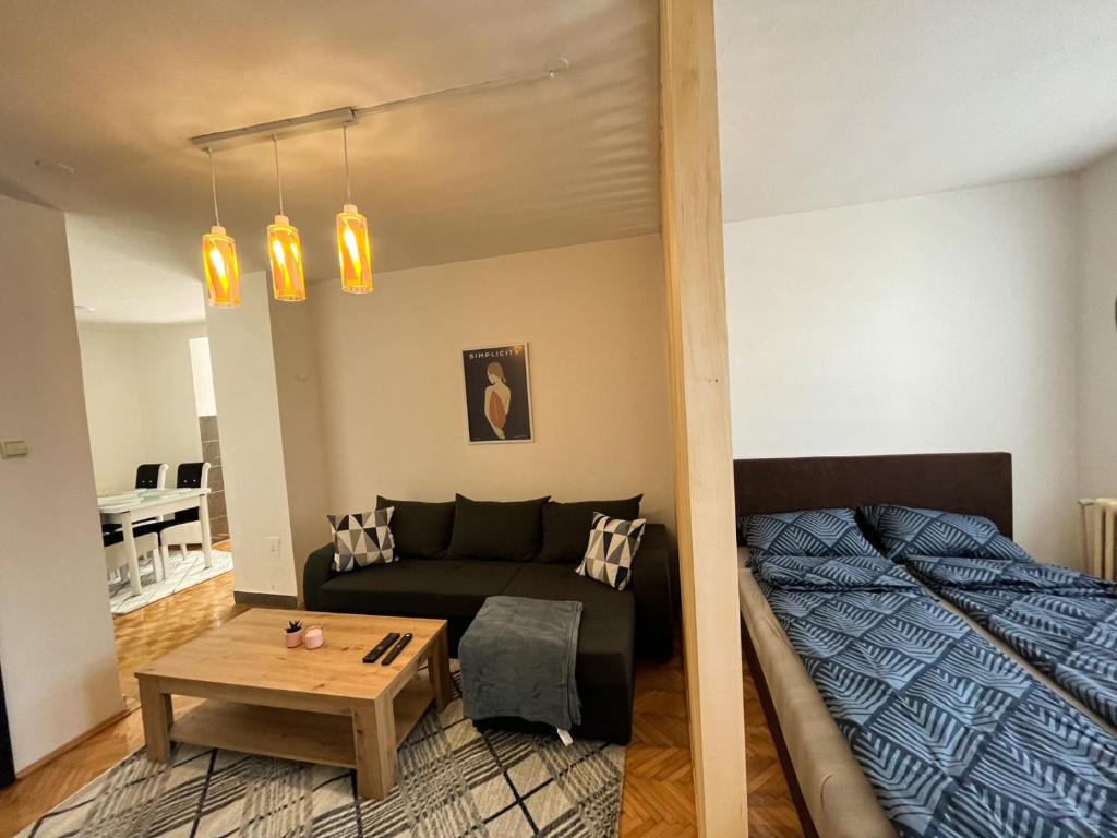 een woonkamer met een bank en een tafel bij Apartman MS in Bosanska Dubica