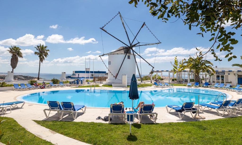 a pool with chairs and a windmill at LongLands Peak at Windmill Hill in Albufeira