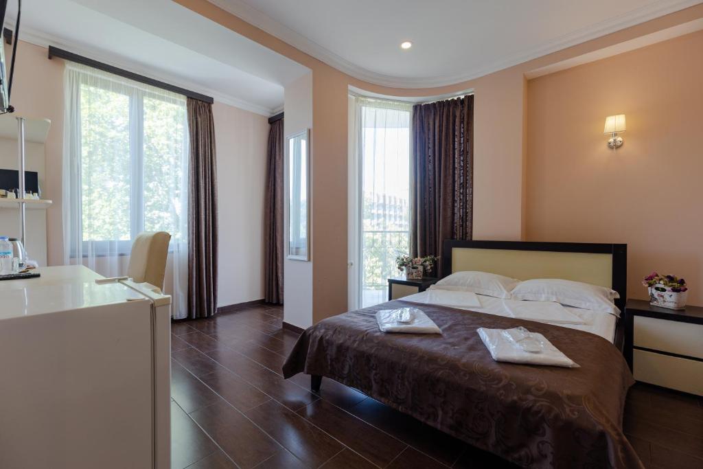 une chambre d'hôtel avec un lit et 2 serviettes. dans l'établissement GNS Hotel, à Ureki