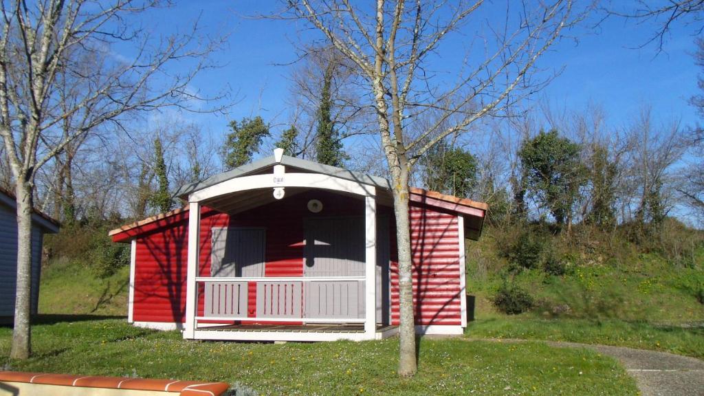 a red and white shed in a yard at Camping Onlycamp L'Argenté in Condom
