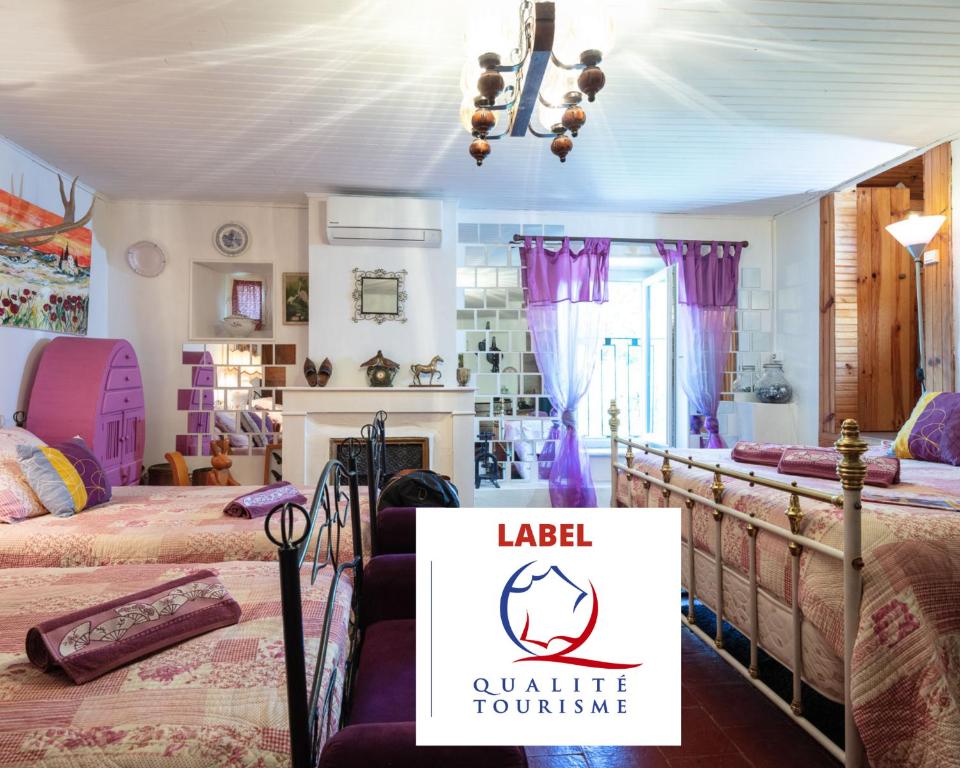 Durfort-et-Saint-Martin-de-SossenacにあるLe Portel des Arnaud Chambres d'Hôtesのベッドが2つあり、「laedia online tourism」と書かれた看板のある部屋