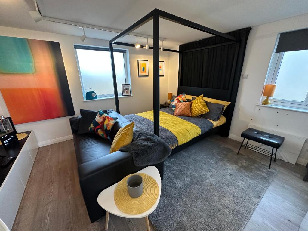 ein Schlafzimmer mit einem Bett, einem Sofa und einem Tisch in der Unterkunft The Studio by Hip Haus in Cleethorpes