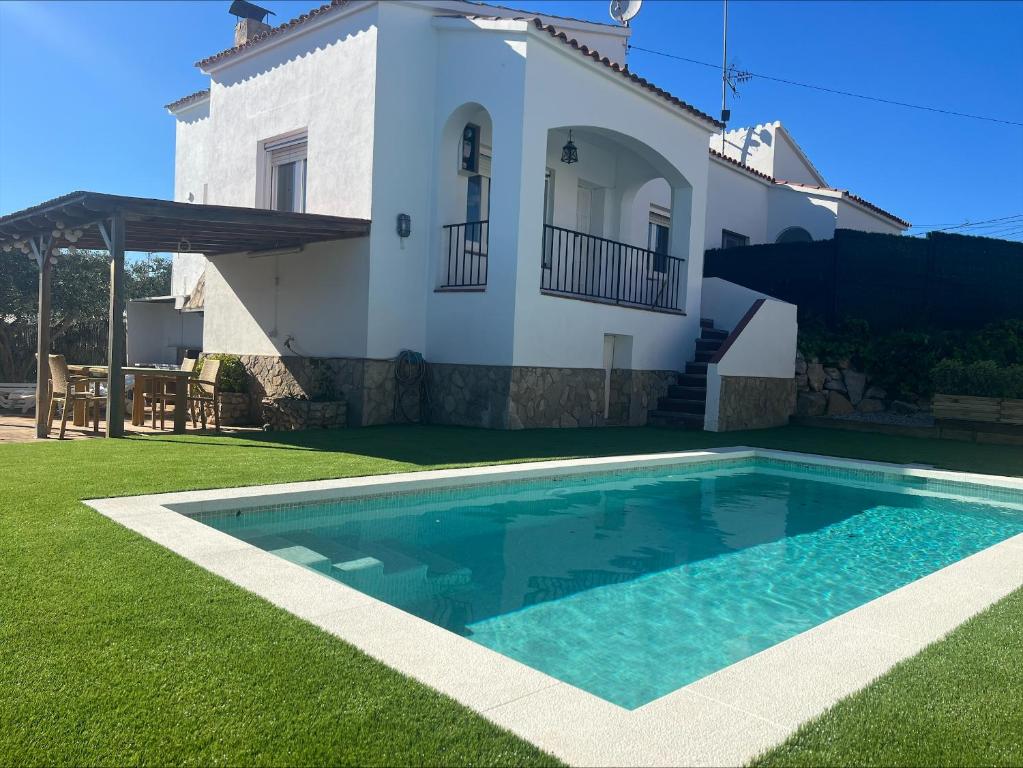 eine Villa mit einem Swimmingpool vor einem Haus in der Unterkunft Alemanya 38 in Torroella de Montgrí