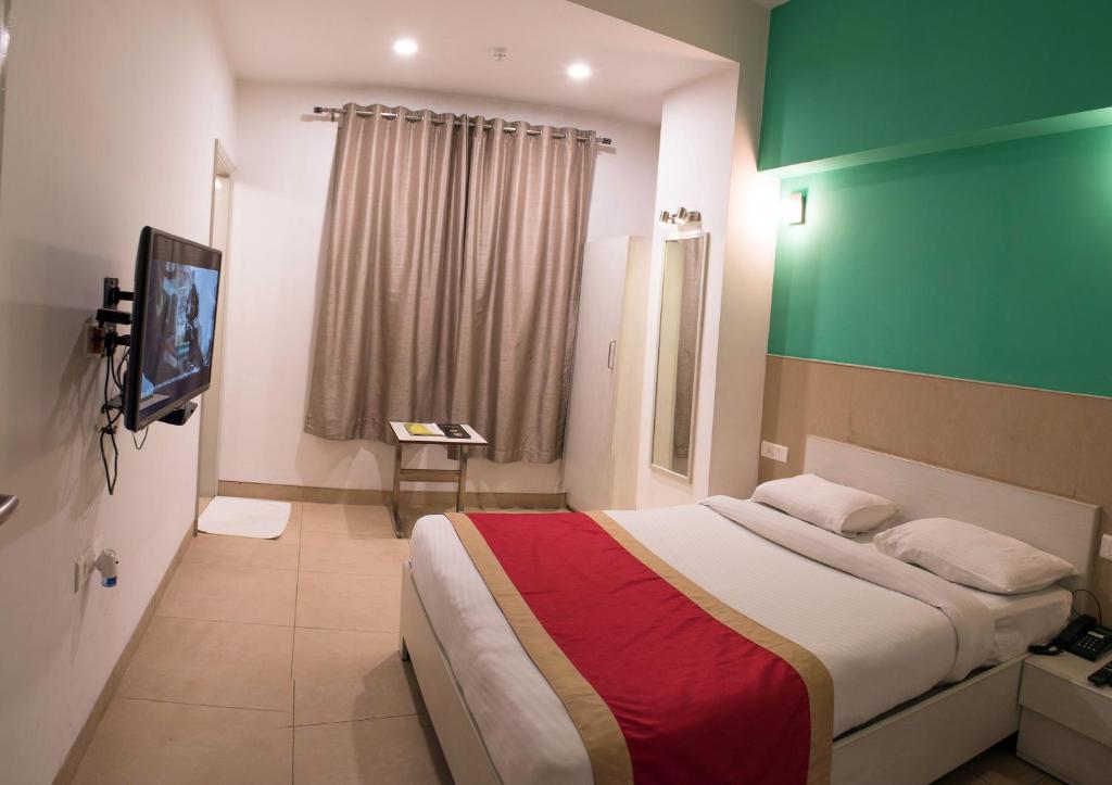 a hotel room with a bed and a green wall at The Opal in Rāmpur