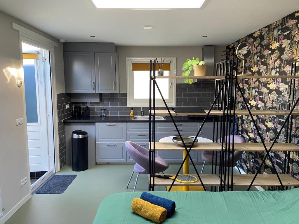 a kitchen with a table and a purple chair at Sfeervol guesthouse, privé tuin en free parking in Rotterdam