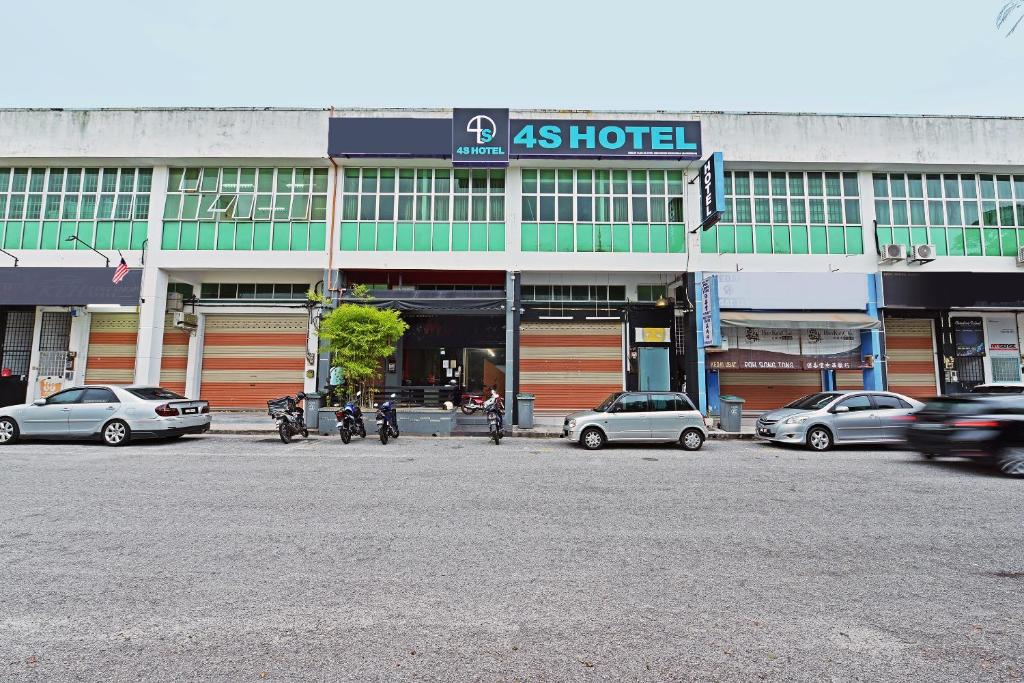 a building with cars parked in front of it at 4S Hotel in Muar