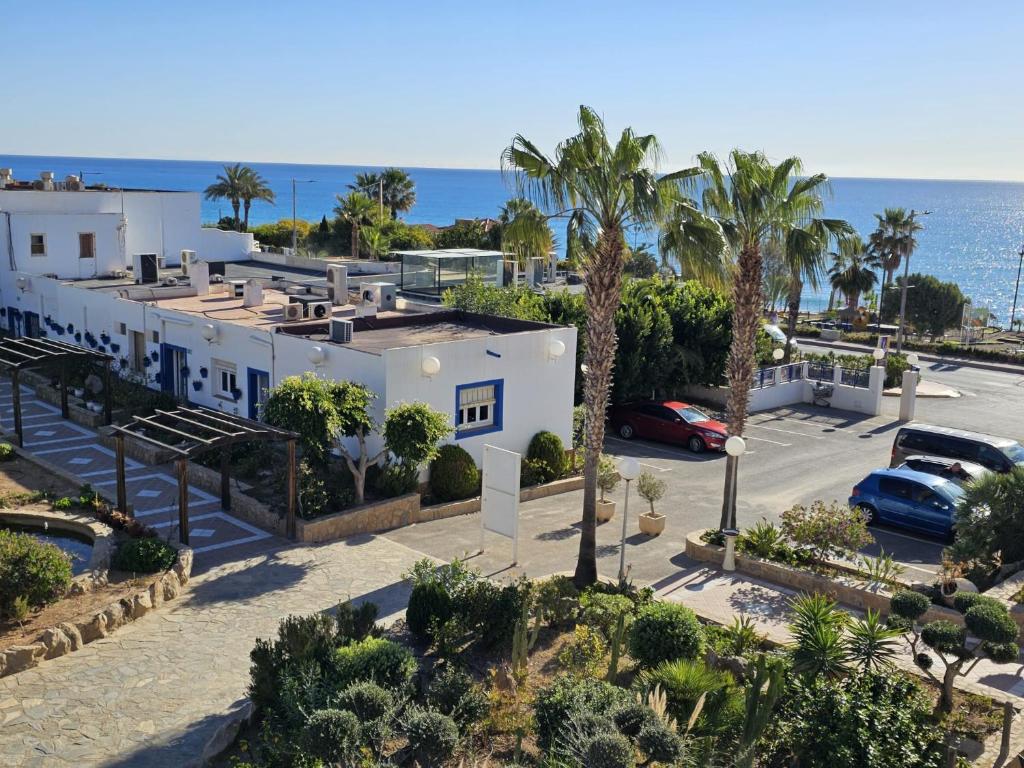 arial view of a building with palm trees and the ocean at Hotel El Puntazo I in Mojácar