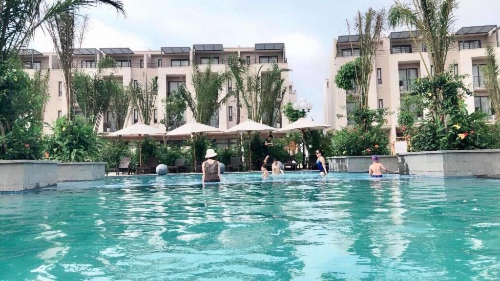 Royal Lotus Hạ Long Resort & Villas في ها لونغ: مجموعة اشخاص في المسبح في الفندق