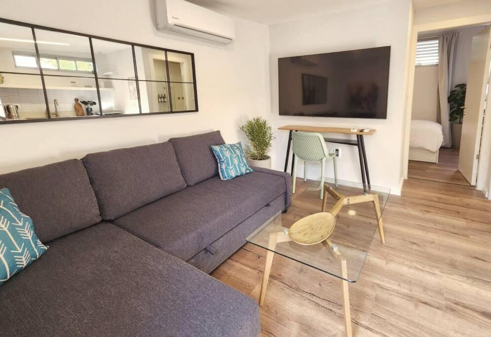 een woonkamer met een bank en een tafel bij Assuta Residence in Ramat HaHayal, Tel Aviv in Tel Aviv