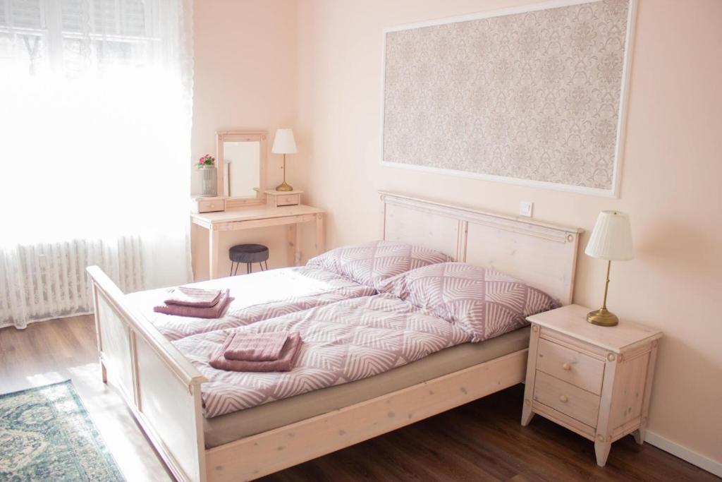 1 dormitorio con 1 cama blanca y 2 almohadas en Broadway Apartments B3, en Debrecen