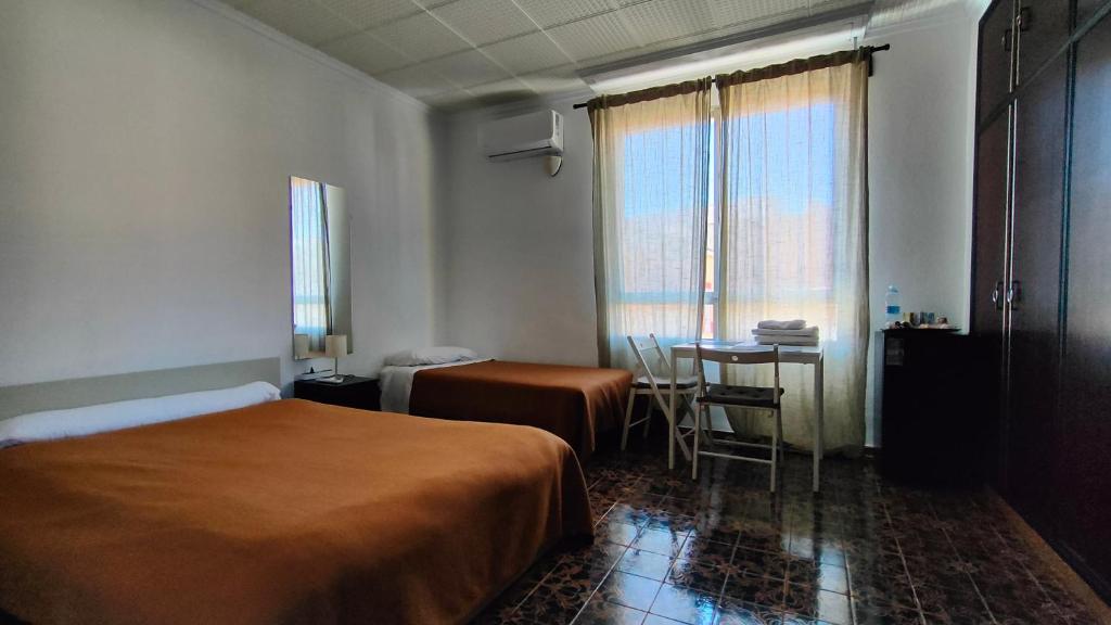 Habitación de hotel con cama y mesa en Pensión Benavente AP-7 3 min - Playa 5 min coche, en Moncófar