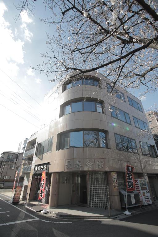 un edificio alto en la esquina de una calle en ゲストハウス昴 en Tokio