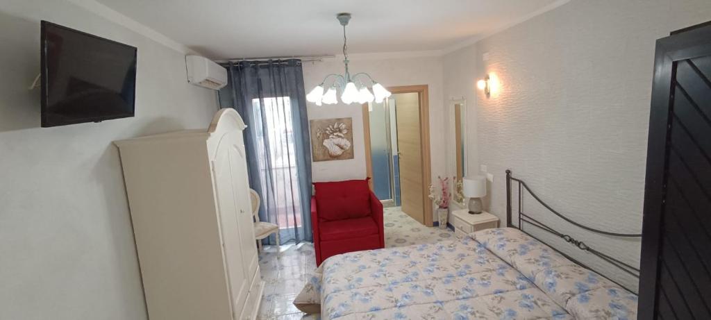 a small bedroom with a bed and a red chair at B&B Appartamenti l'Anfora in Sperlonga