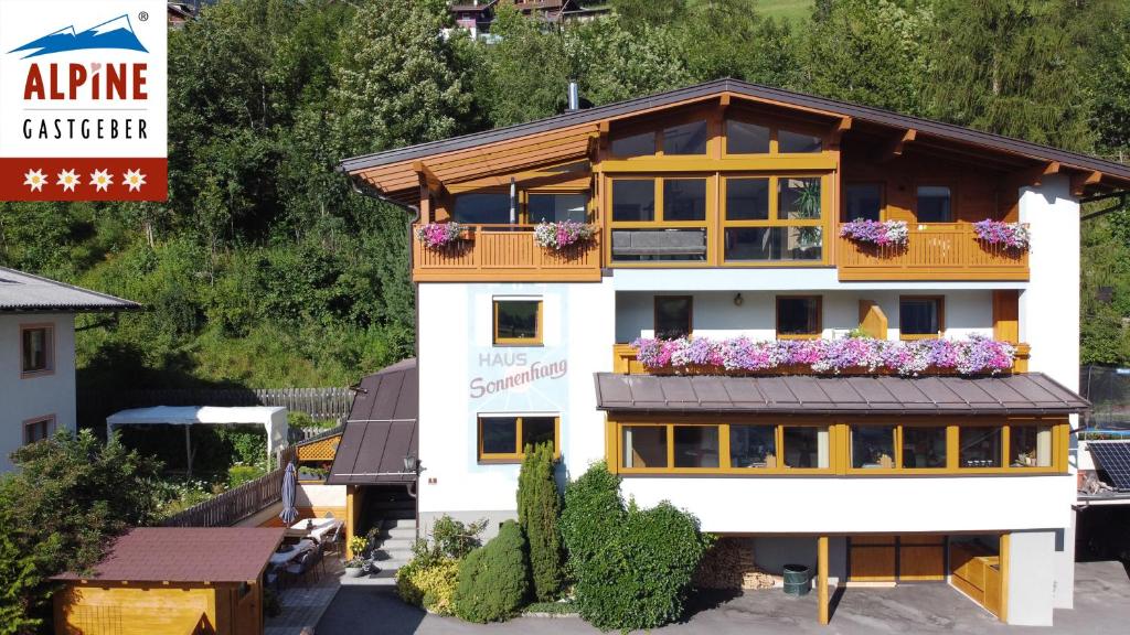 ein Gebäude mit Blumen auf dem Balkon in der Unterkunft Ferienhaus Sonnenhang in Matrei in Osttirol