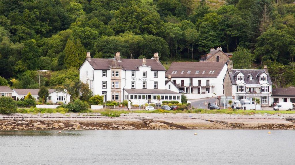 una gran casa blanca en la orilla de un cuerpo de agua en The Royal An Lochan en Tighnabruaich